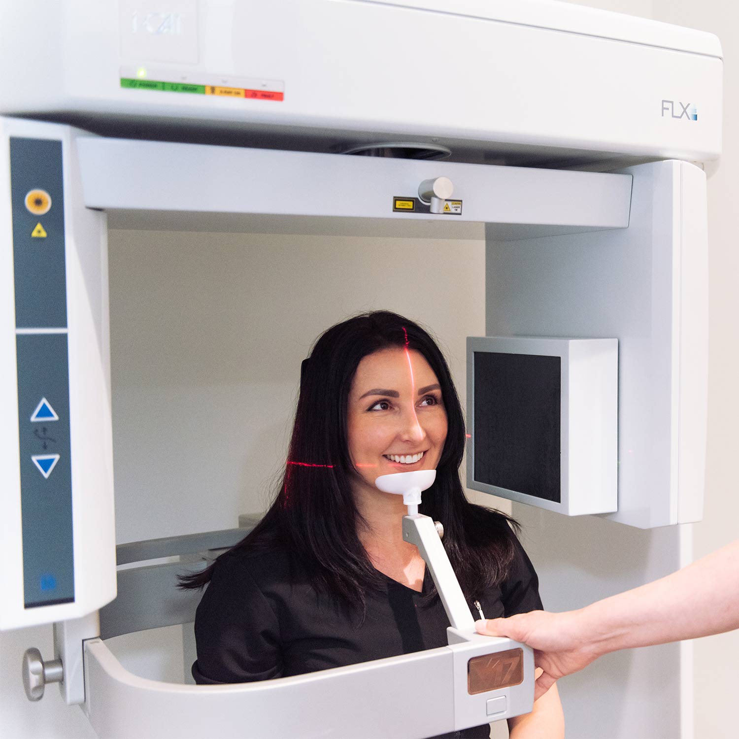A patient smiling inside a CBCT machine at South Calgary Oral Surgery